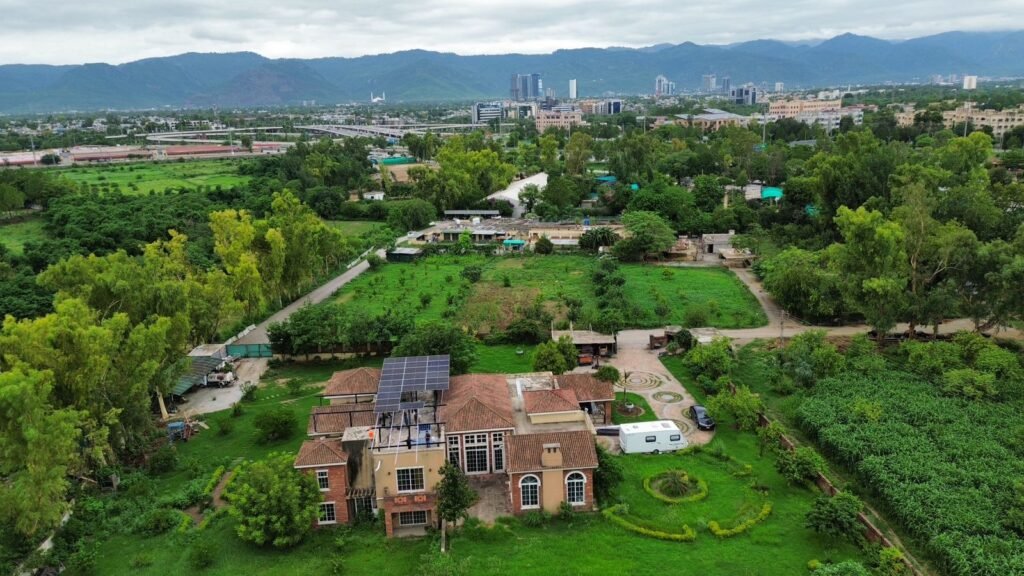 30 kW solar array on a raised steel structure above the farmhouse roof at Ali Farms, H-9, Islamabad